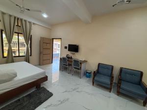 a bedroom with a bed and two chairs and a desk at Hotel Mayur in Bihpuriāgaon