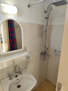 een badkamer met een wastafel en een douche bij YANNA Studios & Apartments in Tsilivi