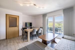 a living room with a couch and a table with chairs at Vila Nina - Apartment Valentina in Vinišće