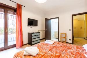 sypialnia z dużym łóżkiem i telewizorem w obiekcie Casa Vacanze La Casetta w mieście Lido di Ostia
