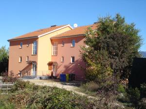 a house with a yellow and pink house at Apartments Dudovic in Šilo