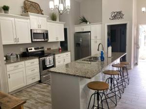 a kitchen with white cabinets and a island with bar stools at 51 The Anchor in Centre