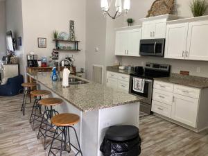 una cucina con mobili bianchi e un bancone con sgabelli di 51 The Anchor a Centre Altre 19 foto