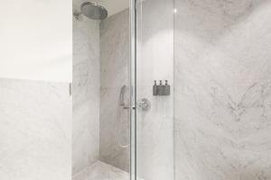 a shower with a glass door in a bathroom at Ando Living - Santa Justa 79 House in Lisbon +102 photos