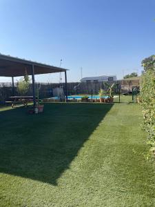 a large grassy yard with a pavilion in the background at Area Parking Caravane in Seville