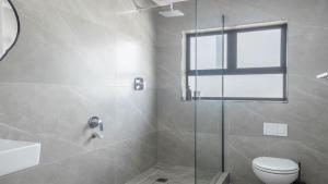 a bathroom with a shower with a toilet and a sink at The Famous Bokaap Villa in Cape Town +33 photos