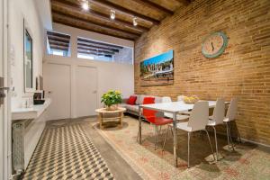 a dining room with a brick wall and a table and chairs at Happy People Plaza España Apartments in Barcelona