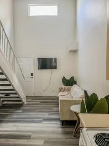 a living room with a couch and a tv on the wall at Charming 2nd Ave Lofts in Downtown San Diego with Parking in San Diego