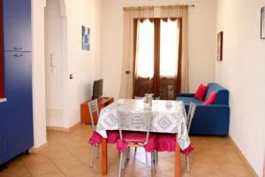 a room with a table and a blue couch at Casa José in San Vito lo Capo