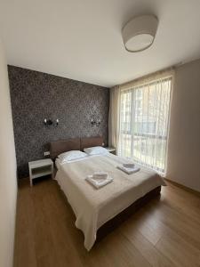 ein Schlafzimmer mit einem großen Bett und einem großen Fenster in der Unterkunft Boutique Home Magnolia in Goldstrand