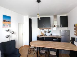 eine Küche mit einem Holztisch in einem Zimmer in der Unterkunft **Arcachon Centre: T3 Moderne avec Terrasse, Proche Plage et Commerces pour 4 Personnes** - FR-1-420-112 in Arcachon + 11 Fotos