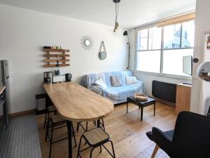 ein Wohnzimmer mit Tisch und Couch in der Unterkunft **Arcachon Centre: T3 Moderne avec Terrasse, Proche Plage et Commerces pour 4 Personnes** - FR-1-420-112 in Arcachon