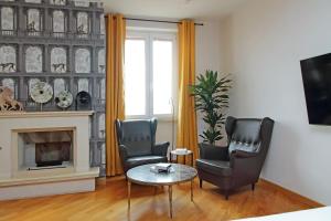 sala de estar con 2 sillas, mesa y chimenea en suity I monkeys apartment, en Roma