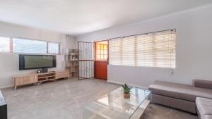 a living room with a couch and a flat screen tv at The Famous Bokaap Villa in Cape Town