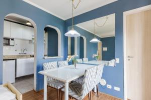 a dining room with blue walls and a table and chairs at Paulista Flat in São Paulo