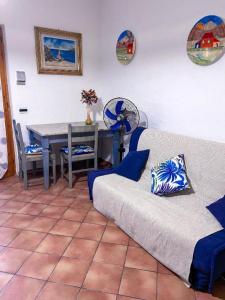 a living room with a couch and a table with a fan at Rifugio Tavolara in San Teodoro