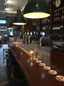 a long bar with glasses and candles on it at Beach Hotel Katwijk in Katwijk