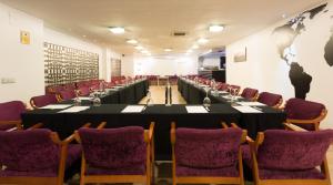 una sala de conferencias con una mesa larga y sillas en Hotel Familia Conde, en Huelva