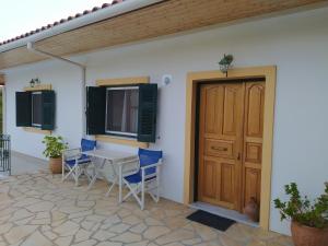 a patio with a table and chairs and a door at Captain's House in Longós