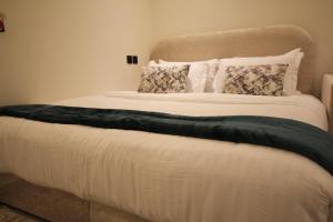 a large bed with a green blanket on it at استديو انيق بـ دخـول ذكي in Riyadh