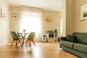 a living room with a table and chairs and a couch at Appartamento FLOWER in Asti