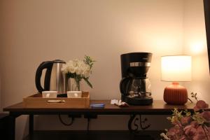 a table with a coffee maker and a lamp on it at استديو انيق بـ دخـول ذكي in Riyadh