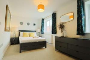 Un dormitorio con una cama, una cómoda y un espejo. en Three Bedroom House in Easton, en Bristol