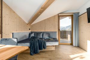 a room with a couch and a large window at Forchnerhof Nature & Mountain View Apartments in Terento