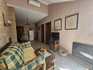 a living room with a couch and a fireplace at Meson Rural Iptuci in Prado del Rey