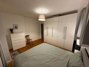 a bedroom with a large bed and a dresser at Stirling Haven: Charming 3B Apt in City Centre in Stirling