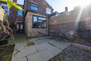 a patio with a table in front of a brick building at Western House - Central Warrington - Sleeps 5 in Warrington