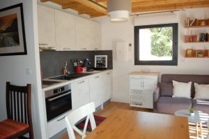 a kitchen and living room with a table and a couch at Gîte Le Logis Vallat in Fuveau