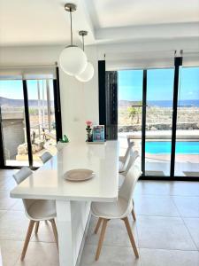 a white dining room with a white table and chairs at Harmony - Beach & Dream rentals in Playa de las Americas
