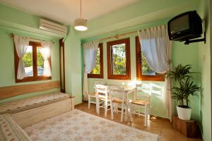 a room with a table and chairs and a television at Victoria's Guesthouse in Damouchari