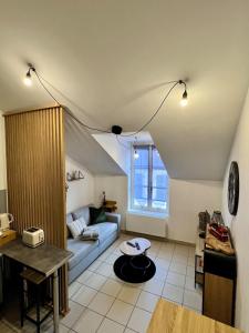 a living room with a couch and a table at Charmant appart T2 tout équipé in Montbéliard