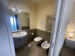 a bathroom with a sink and a toilet and a mirror at Appartamento Attico - Penthouse - Palazzo San Matteo in Palermo +8 photos