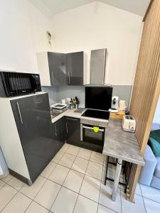 a small kitchen with a desk with a laptop on it at Charmant appart T2 tout équipé in Montbéliard +29 photos