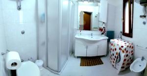 a white bathroom with a sink and a shower at Casa vacanze Pietro e Michela in Giungano