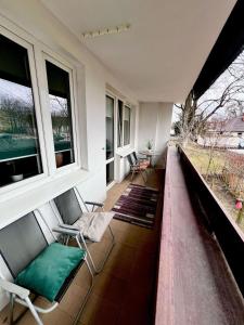a balcony with two chairs and two windows at Apartament Sieroszewskiego in Puławy