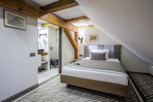 a bedroom with a bed and a staircase at Michaelson Boutique Hotel & SPA Brícoła in Klaipėda +66 photos