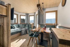 a room with a bed and a table and chairs at Forchnerhof Nature & Mountain View Apartments in Terento