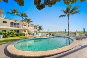 a swimming pool in front of a house with palm trees at Pool Beachfront Studio in Fort Lauderdale