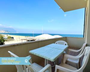 a table and chairs on a balcony with the beach at RS320 - Marcelli, bilocale in residence fronte mare 1p in Marcelli