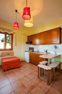 a kitchen with red lights and a table and bench at Victoria's Guesthouse in Damouchari +57 photos