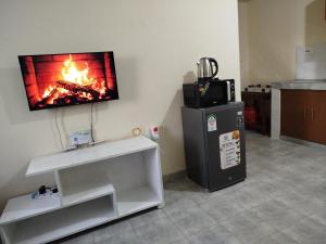 a kitchen with a fireplace and a tv on the wall at Milly's apartment in Malindi