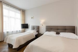 2 Betten in einem Hotelzimmer mit Fenster in der Unterkunft Hotel Floryan Old Town in Krakau