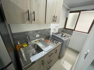 a small kitchen with a sink and a stove at Apartaloft 207 Near to hospital San Jorge in Pereira