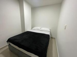 a small white room with a bed in it at Apartaloft 207 Near to hospital San Jorge in Pereira +2 photos