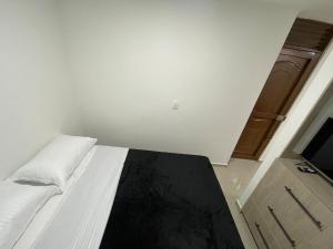a bedroom with a white bed and a wooden door at Apartaloft 207 Near to hospital San Jorge in Pereira