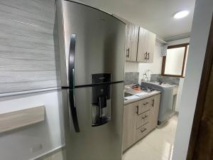 a stainless steel refrigerator in a small kitchen at Apartaloft 207 Near to hospital San Jorge in Pereira
